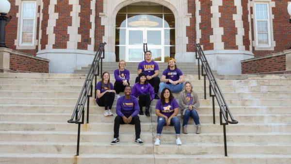 Students sitting on front steps of building